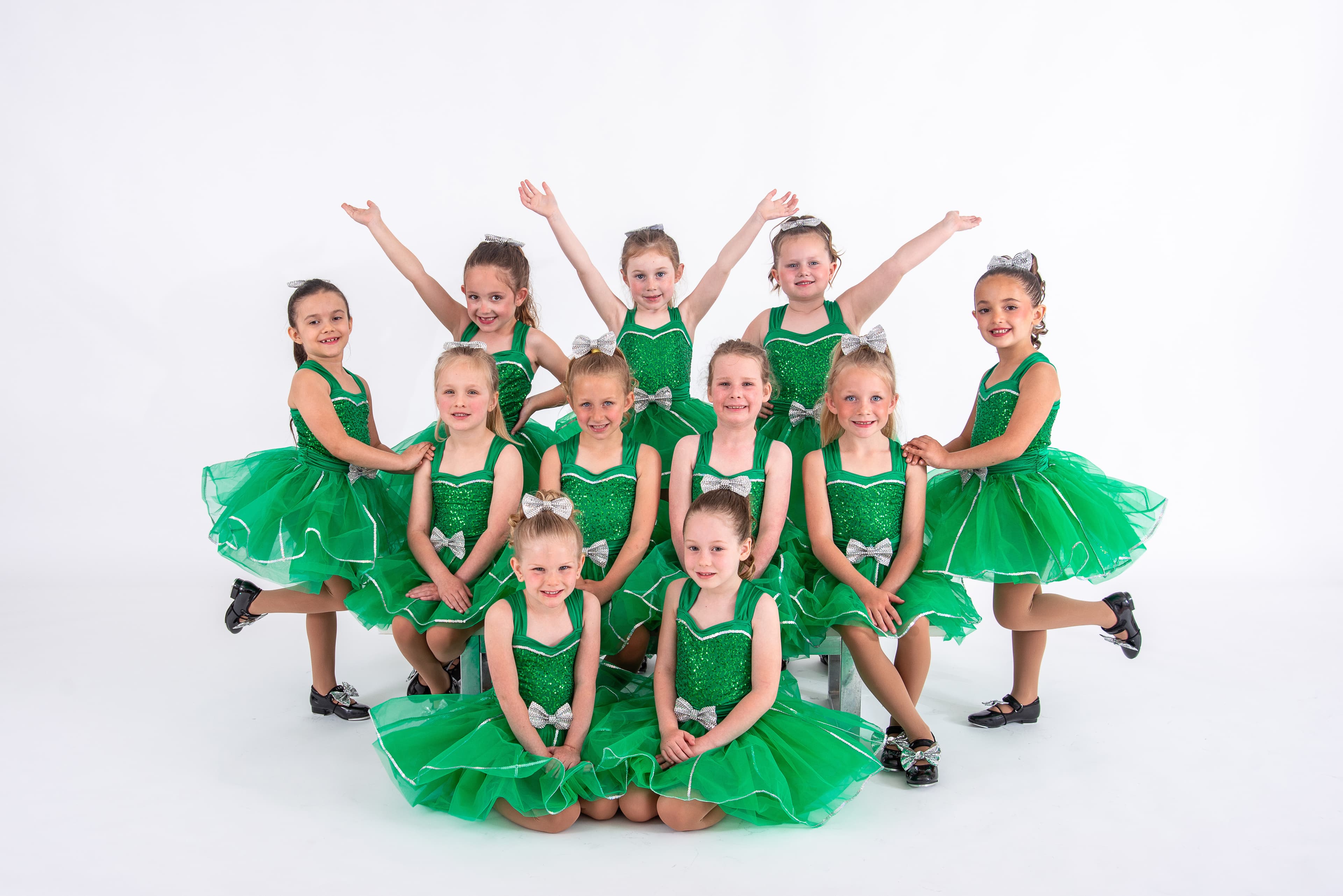 Youth tap dancers in green costumes