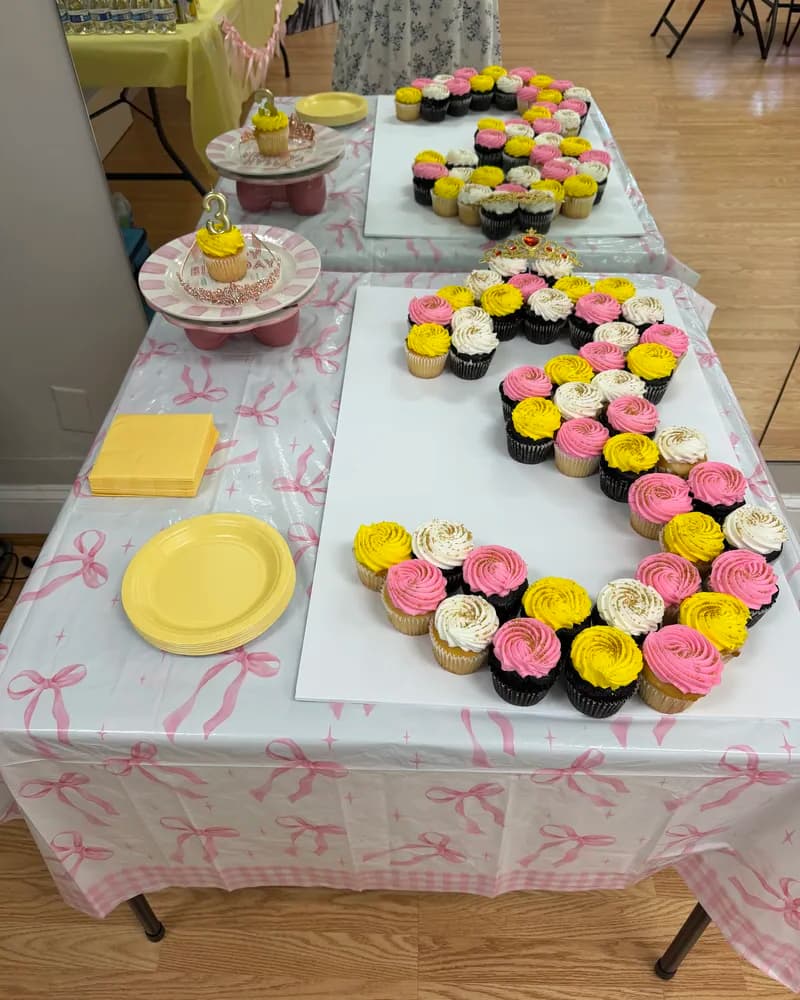 Decorated birthday party table with cupcake letter cake