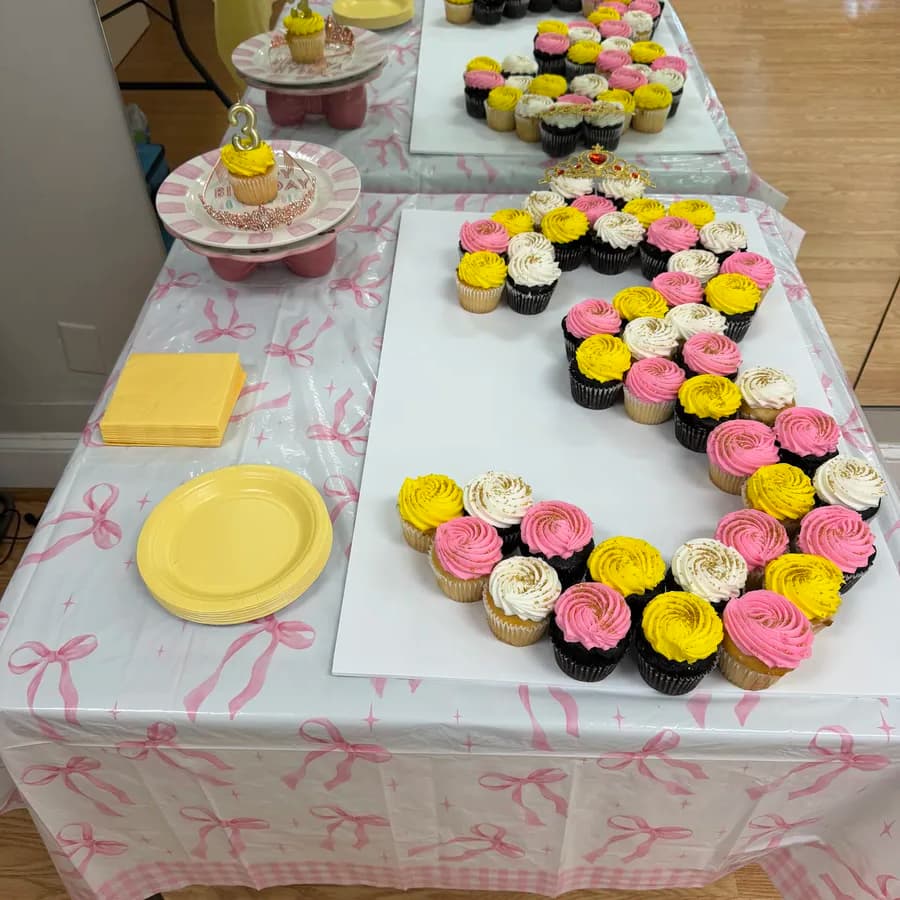 Cupcake letter cake spelling out a birthday message on a decorated party table