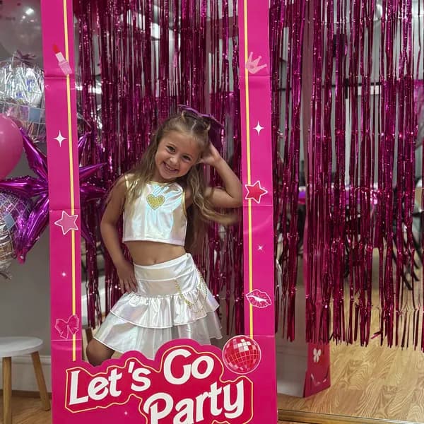 Birthday girl posing in Barbie-themed photo cutout